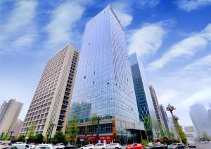 un grand bâtiment avec des voitures garées devant dans l'établissement Borrman Hotel Guiyang Guanshanhu International Conference Center Metro Station, à Jinzhuzhen