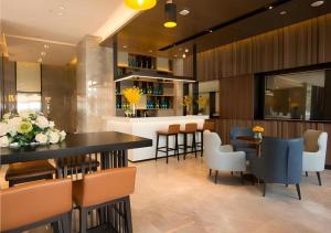 武漢市にあるEcharm Hotel Wuhan Vanke Future Center Wulidun Metro Stationのテーブルと椅子とバーのあるレストラン