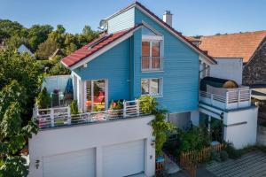 a blue house with a white fence at Haus Himmelblick mit privater Sauna in Sasbach am Kaiserstuhl