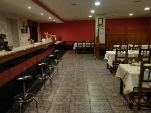 a restaurant with tables and chairs and a bar at Pension Meson Paz in Puentedeume