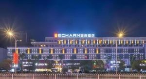 a large building with lights in front of it at night at Echarm Hotel Enshi Cultural Center Xintiandi in Enshi