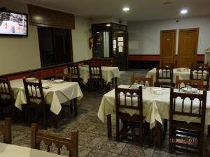 a dining room with tables and chairs and a tv at Pension Meson Paz in Puentedeume +11 photos