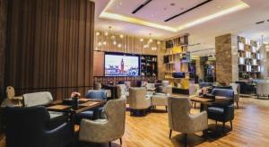 a restaurant with tables and chairs and a television at Echarm Hotel Jingjiang Bus Passenger Station Fanggu Street in Jingjiang