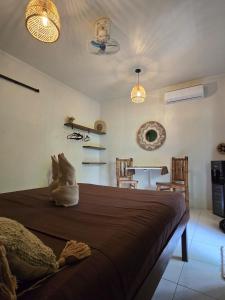 a bedroom with a bed with two chairs and two lights at Little house in El Nido
