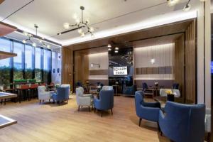 a restaurant with blue chairs and tables and windows at Echarm Hotel Nanning Chaoyang Square River View in Nanning