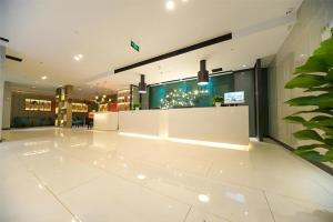 a lobby with a white floor and a bar at Echarm Hotel 1st Affiliated Hospital of Suzhou University Pingjiang in Suzhou