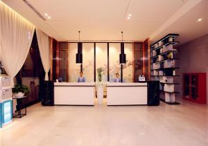 a lobby with two people sitting at reception desks at Echarm Hotel Xian Ming City Wall South Gate in Xi'an