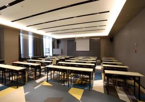 a classroom with rows of desks and a whiteboard at Echarm Hotel Changsha Gaoqiao in Changsha