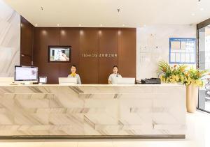 two women sitting at a reception desk in a lobby at City Comfort Inn Nanning Dashatian Metro Station in Nanning