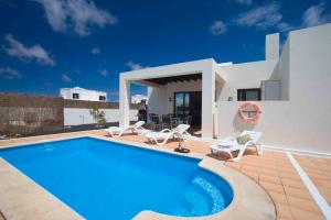 a villa with a swimming pool and a house at Ereza Villas Las Buganvillas in Playa Blanca