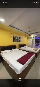 two beds in a room with yellow walls at Hotel sai advika in Guirim +5 photos