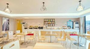 une salle à manger avec tables et chaises et une cuisine dans l'établissement City Comfort Inn Guilin Two Rivers and Four Lakes Sun and Moon Shuangta, à Guilin