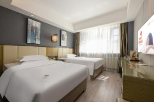 Postel nebo postele na pokoji v ubytování Jinyi Hotel Bayannur Linhe Victoria Mall Branch + 11 fotografií