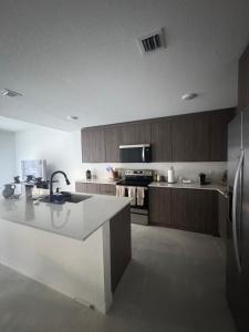 a kitchen with a sink and a refrigerator at Modern room with kitchen and backyard access in Homestead