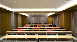 a lecture hall with rows of desks and red chairs at City Comfort Inn Jinan Railway Station Daming Lake in Jinan