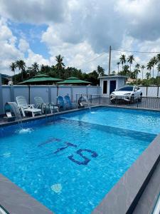 a large blue swimming pool with chairs and a car at Santai TTS BATU RAKIT in Kuala Terengganu