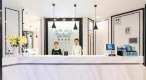 zwei Personen, die an einer Theke in einer Apotheke stehen in der Unterkunft Xana Hotelle· Wulumuqi High Speed Railway Station Baonengcheng in Ürümqi