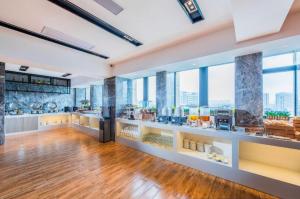 HuangshigangにあるEcharm Hotel Huangshi Yingbin Avenueの窓と食べ物が置かれたカウンターのある広い部屋