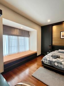 ein Schlafzimmer mit einem Fenster mit einem Bett und einem Fenstersitz in der Unterkunft 2BR Pool Accesss at Blue Lagoon - Near Sheraton Hua Hin in Hua Hin + 21 Fotos