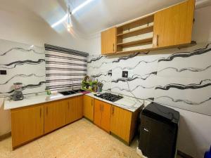 a kitchen with a black and white pattern on the wall at Soothing Haven in Ibadan