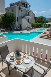 a dining room table with chairs and a patio at Lefkadio Suites in Lefkada