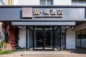 un bâtiment avec une enseigne sur la façade dans l'établissement James Joyce Coffetel Tianjin Railway Station, à Tianjin