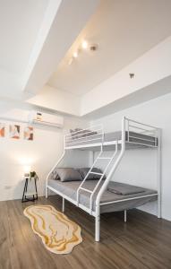 a white bunk bed in a white room with a rug at Charming Modern 1 BR Loft in Sampong
