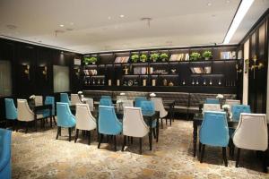 un restaurant avec des tables et des chaises bleues et blanches dans l'établissement Xana Hotelle Nanchang Hongdu Middle Avenue Provincial TV Station, à Nanchang County