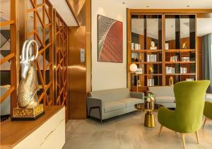 a living room with a couch and a chair at Borrman Hotel Dongguan Dongcheng Wanda Plaza Tianbao Metro Station in Dongguan