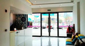 - un hall avec une grande porte en verre dans un bâtiment dans l'établissement Pai Hotel Guang'an Railway North Station, à Guang'an
