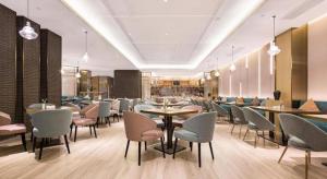 a restaurant with tables and chairs in a room at The Hotel V Nanjing Lishui in Lishui