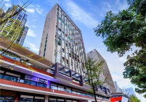 a tall building in a city with a street at Echarm Hotel Guiyang North High-speed Railway Station in Guiyang