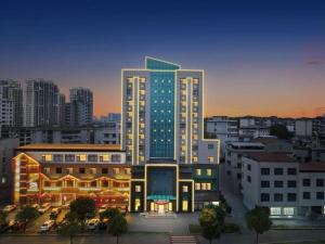 un grand bâtiment éclairé dans une ville dans l'établissement City Comfort Inn Xianning Yinquan Avenue, à Wenquanzhen