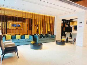 - un hall avec un canapé bleu et des chaises dans l'établissement City Comfort Inn Xianning Yinquan Avenue, à Wenquanzhen