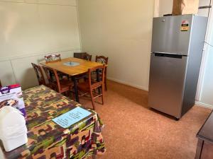 a kitchen with a table and a refrigerator at Royal Hotel Eromanga in Eromanga