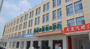 GuangzongGreen Tree Inn Express Xingtai Guangzong Development Zone Xingqing Road的正面有标志的建筑物