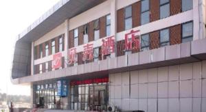 a building with signs on the side of it at Shell Hotel Anhui Bozhou Woyang County Lexing Road Bus Station in Guoyang