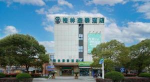 un grand bâtiment blanc avec une enseigne dessus dans l'établissement Green Tree Inn Fengxian New City Metro Station Jiukeshu Art Center, à Sanguantang