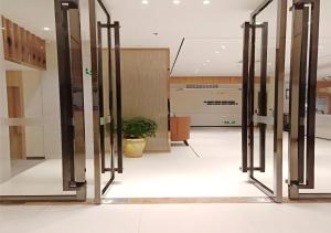un hall d'entrée avec une rangée de portes vitrées dans un bâtiment dans l'établissement City Comfort Inn Qingyuan Yingde Weiduoli Square, à Yingde