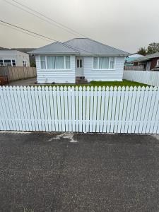 a white fence in front of a white house at Gee's House in Upper Hutt +6 photos