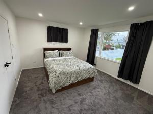 a bedroom with a bed and a window at Gee's House in Upper Hutt