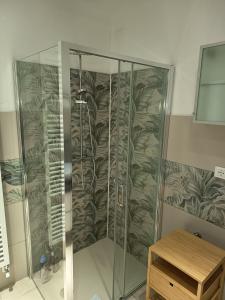 a shower with a glass enclosure with a wooden table at 2 passi dalla fiera SOGNI D'ORO in Verona