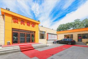 un bâtiment avec une voiture garée devant dans l'établissement Shell Hotel Beijing Fangshan District Chengguan Metro Station, à Fangshan
