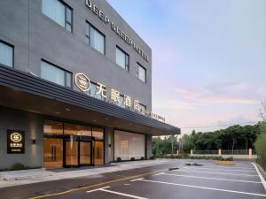 an empty parking lot in front of a hotel at Deep Sleep Hotel Xuzhou High-Speed Railway Station East Square Oubeisha in Xuzhou