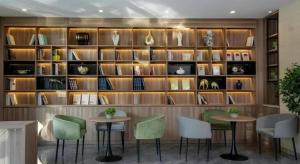 a room with two tables and a shelf with books at GreenTree Inn Express Hebei Tangshan Guyan District Xinguang Road in Tangjiazhuang