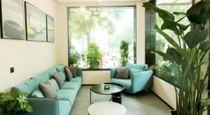 a living room with a blue couch and a table at GreenTree Inn Express Henan Xinyang Huaibin County in Zhengzhou +43 photos
