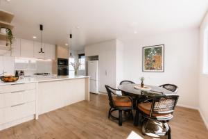 a kitchen and dining room with a table and chairs at Tresco Apartments - Quiet Luxury in the Heart of Blenheim in Blenheim