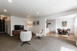 a living room with a table and chairs and a television at Tresco Apartments in Blenheim