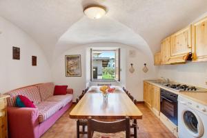 ピーラにあるCaratteristico e accoglienteのキッチンとテーブルとソファのあるリビングルーム