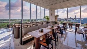 a restaurant with tables and chairs and large windows at Nous Land Beijing in Beijing